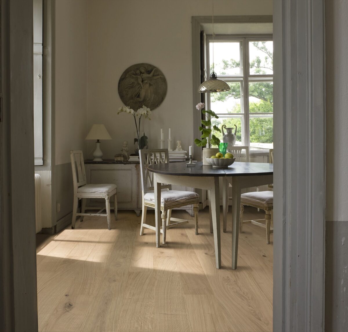 Decorated dining space with Kahrs Oak Nouveau White Prefinished Hardwood.