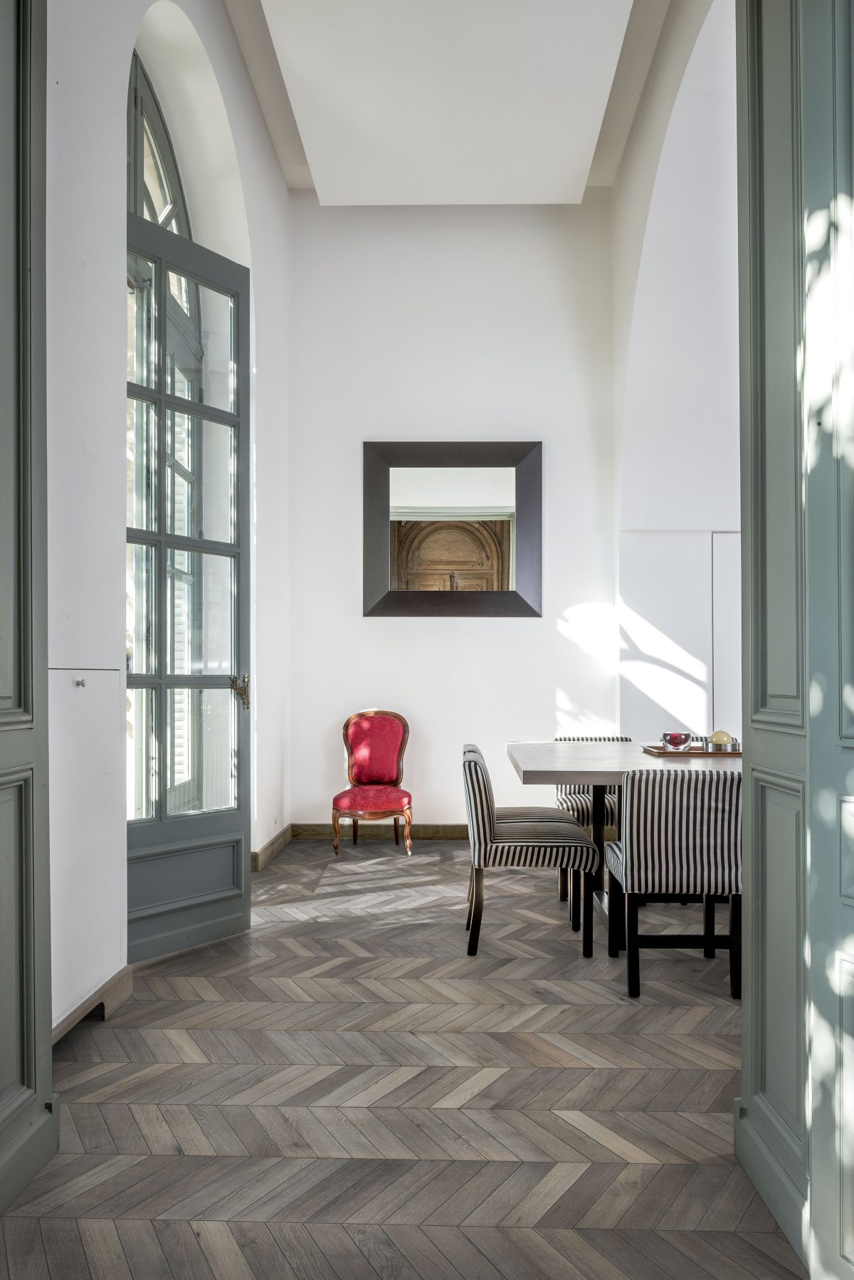 Decorated dining space with Kahrs Chevron Grey Prefinished Hardwood.